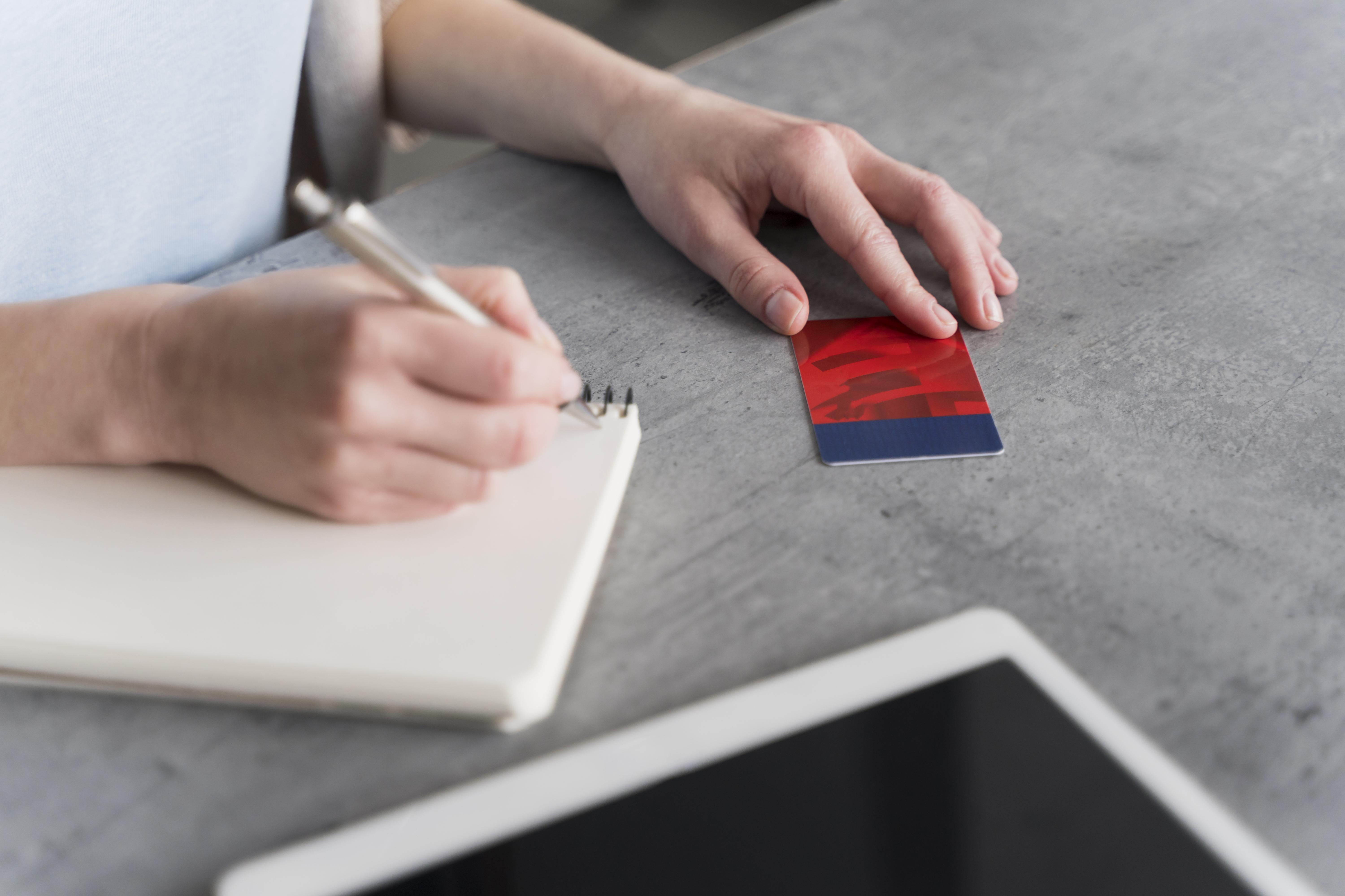 Une personne écrit sur une page blanche et vierge de son cahier.